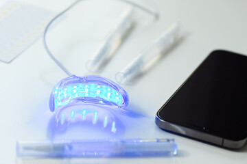 whitening kit at home with LED lamp, on a white background, snow-white smile, dental care, dentistry