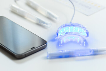 whitening kit at home with LED lamp, on a white background, snow-white smile, dental care, dentistry