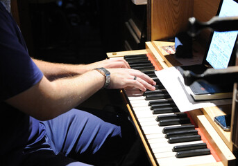 Organist musician repairing and tuning a church pipe organ. Musician playing the keyboard of a pipe...