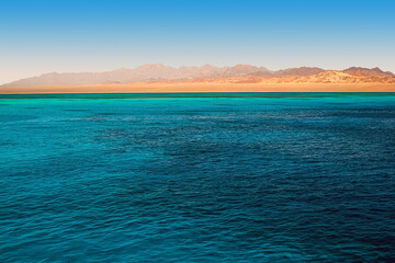 Obraz premium Beautiful view of the golden mountain coast from the azure sea. Red Sea, Egypt