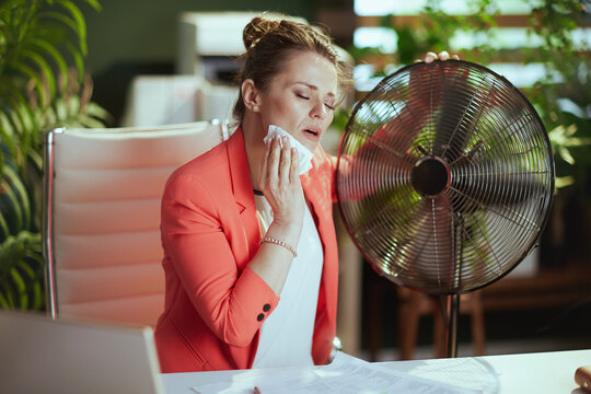 40 years old bookkeeper woman in green office suffer from heat