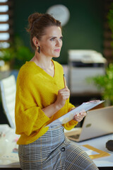 trendy business owner woman in sweater in green office