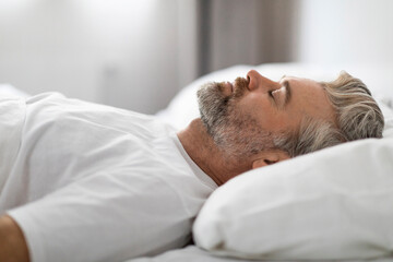 Middle aged man sleeping in bed at home