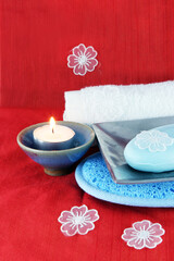 Obraz na płótnie Canvas Burning candle with soap in a dish - spa products