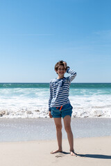 Fototapeta na wymiar Happy young boy on the beach, vertical image