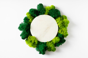Eco and beauty concept with marble podium and moss on white background