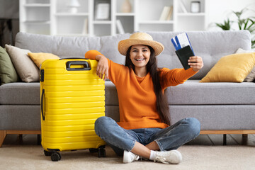 Happy indian woman going vacation, showing flight tickets