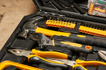 adjustable wrench, pliers, hammer close-up. lie in a tool case
