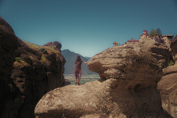 Woman on rock formation and castle