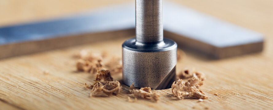 Countersink drill bit with steel triangle ruler make sink in hole for screw in wooden oak plank