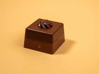 Dark and milk chocolate candy. Chocolate candy on an orange background.