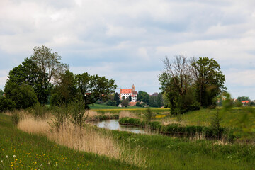 View of the Gablinger castle over the green meadows and fields in the Schmutter valley near Augsburg