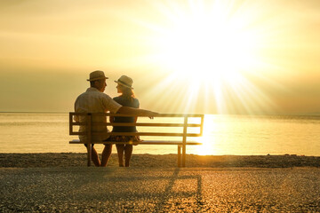 A happy couple on a bench by the sea on nature in travel silhouette