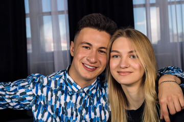 Happy young handsome man and a cute blonde girl are hugging. a happy couple of young people.