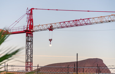 Forced perspective of a construction crane holding the moon