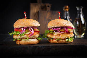 Chicken hamburger. Sandwich with chicken burger, tomatoes, cheese and lettuce. Cheeseburger.