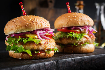 Chicken hamburger. Sandwich with chicken burger, tomatoes, cheese and lettuce. Cheeseburger.