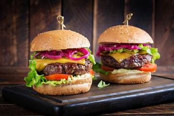 Beef hamburger. Sandwich with beef burger, tomatoes, cheese, pickled cucumber and lettuce....