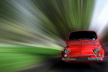 Fototapeta na wymiar Small red generic car speeding in the country side.