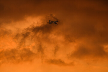 Airplane flying under a golden sky