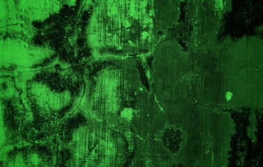 A textured green grunge background with dark patches and rough surface
