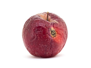 Old wormy apple with wrinkles on a white isolated background