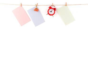 close up of a colorful note paper, clock on rope on white background