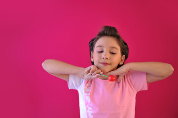 criança feliz com doce pirulito em fundo rosa 