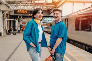 Beautiful couple at railway station waiting for the train. Woman and man running to board a train