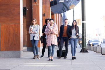 Group of people walking on a street with confidence. Businessmen and businesswomen traveling...