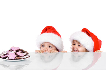 Two kids yearning for the christmas cookies - isolated