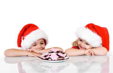 Happy kids with a plate full of christmas gingerbread cookies - isolated