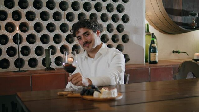 Wine taster looking glass with swirling red drink closeup. Sommelier degustation