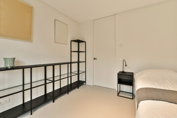 a bedroom with white walls and black shelvings on the wall next to the bed in the room is empty