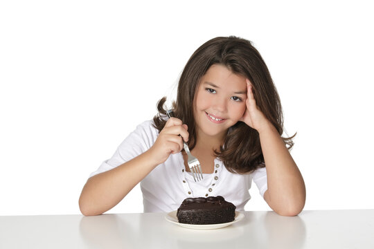 Cute Caucasian child eating a slice of chocolate cake