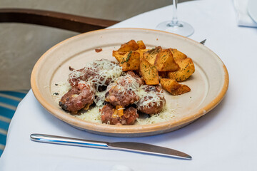 Serbian food meat Ustipci Rostilj with baked potato on plate in restaurant 