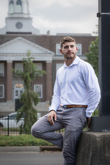Obraz premium Male student is leaning on lamp post in front of University of Louisville's College of Engineering.