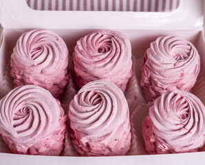 tasty delicious homemade zephyr pink marshmallows with blackberries taste.sweet dessert in box,on kitchen towel,gray tiles surface.whisk tea strainer accessories,sugar powder.pattern close up texture