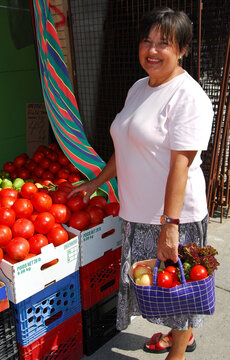 Attractive mature woman buying vegetables at farmer's market