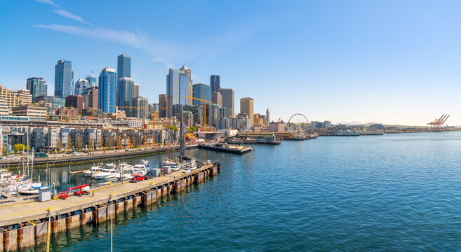 Panoramic view of the Seattle Waterfront along the Puget Sound with skyscrapers, the Pike Place Market district, the Great Wheel and Safeco Field in view from the harbor in Seattle Washington, USA.