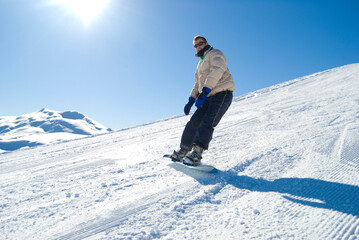 Fototapeta na wymiar Snowboarder on a mountain in a bright sunny day stock photo