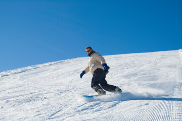 Naklejka na ściany i meble Snowboarder on a mountain in a clear blue sunshine day stock photo