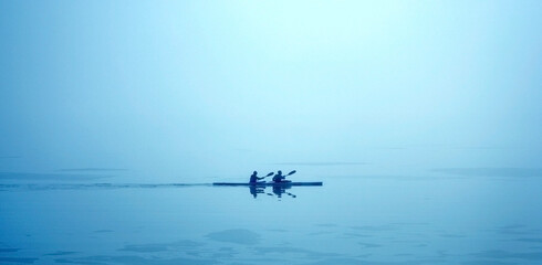 Wonderful quiet picture of two people canoeing very early in the morning.    Image details:  I have edited the contrast of this picture. I have not used any filters or noise reduction. The canoe is in