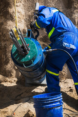 Latino Engineer Working on Anchoring System at Building Foundation Construction Site