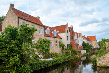 Fototapeta na wymiar Bruges, Belgium - Old brick houses in the city center built over a canal with boats