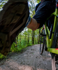 cyclist riding on forest path, bottom view of bicycle