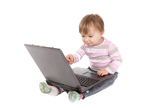sweet baby girl playing on laptop.over white background