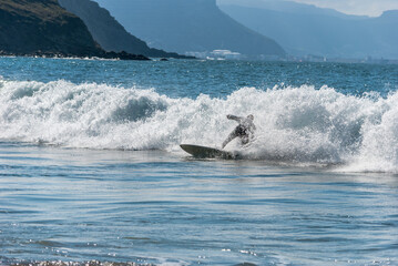 A surfer rides a wave in the ocean.. Sopelana beach near Bilbao (Basque Country).