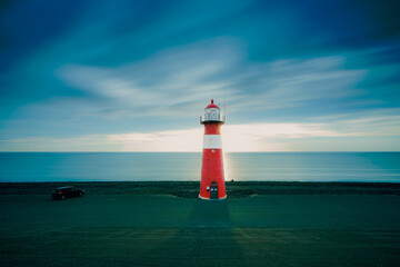 Fototapeta premium Red & white vintage lighthouse at dutch coast in west kapelle