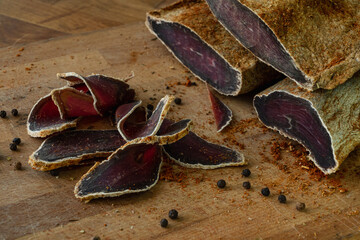 Dried beef basturma sliced on a cutting board